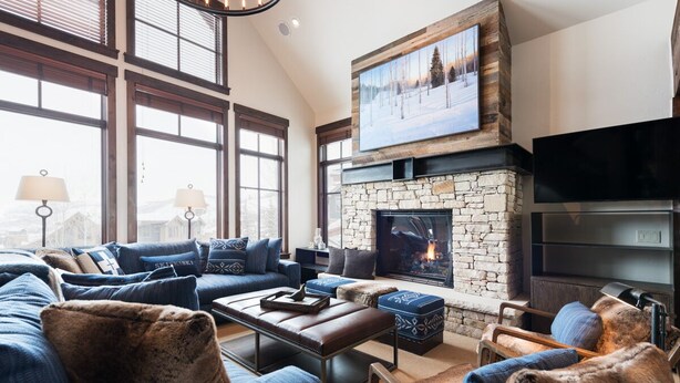 A cozy living room with a stone fireplace, a large flat-screen TV mounted above it, and a comfortable seating area with sofas and a coffee table. - Silver Star 40 | Theater Room | Hot Tub (Park City)