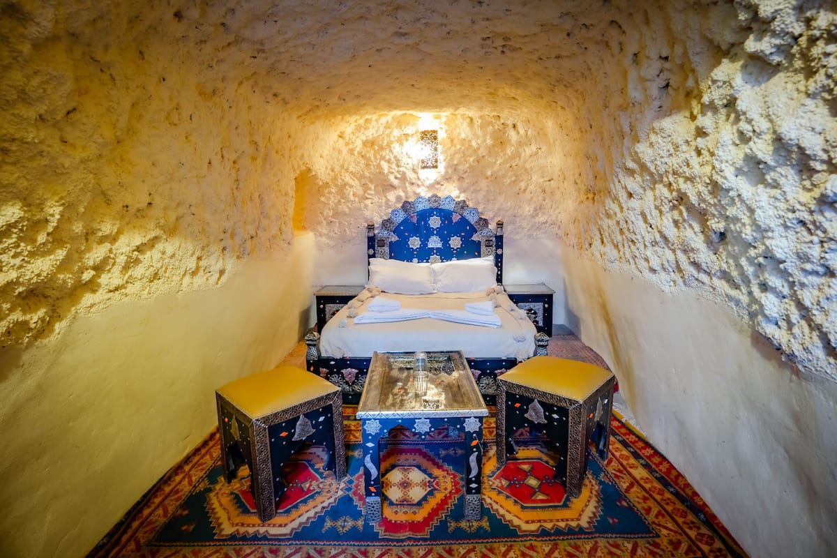 Une petite pièce agréable, avec un lit, deux tabourets et une table.