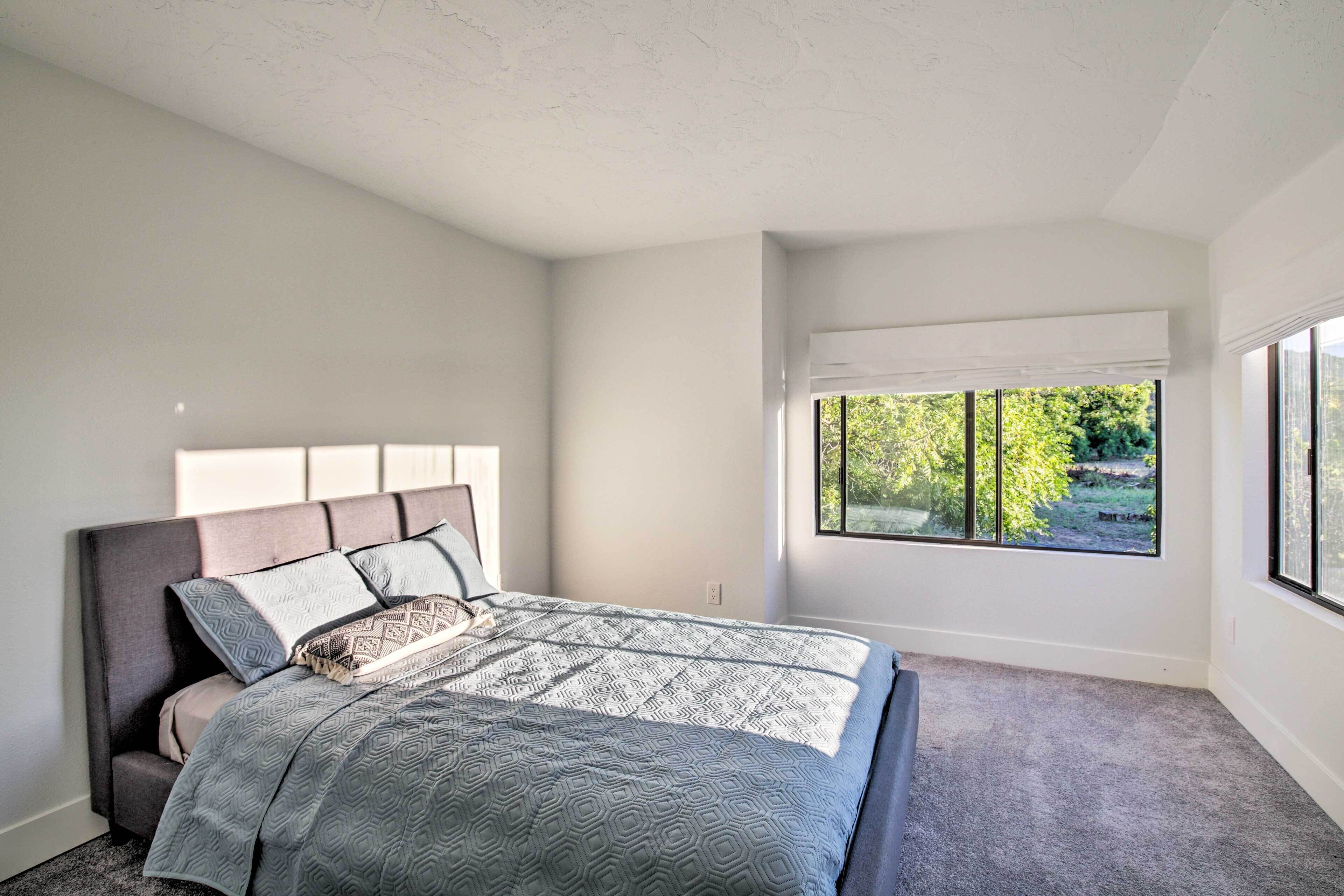 Une chambre à coucher avec un lit, une fenêtre et une vue sur la verdure.
