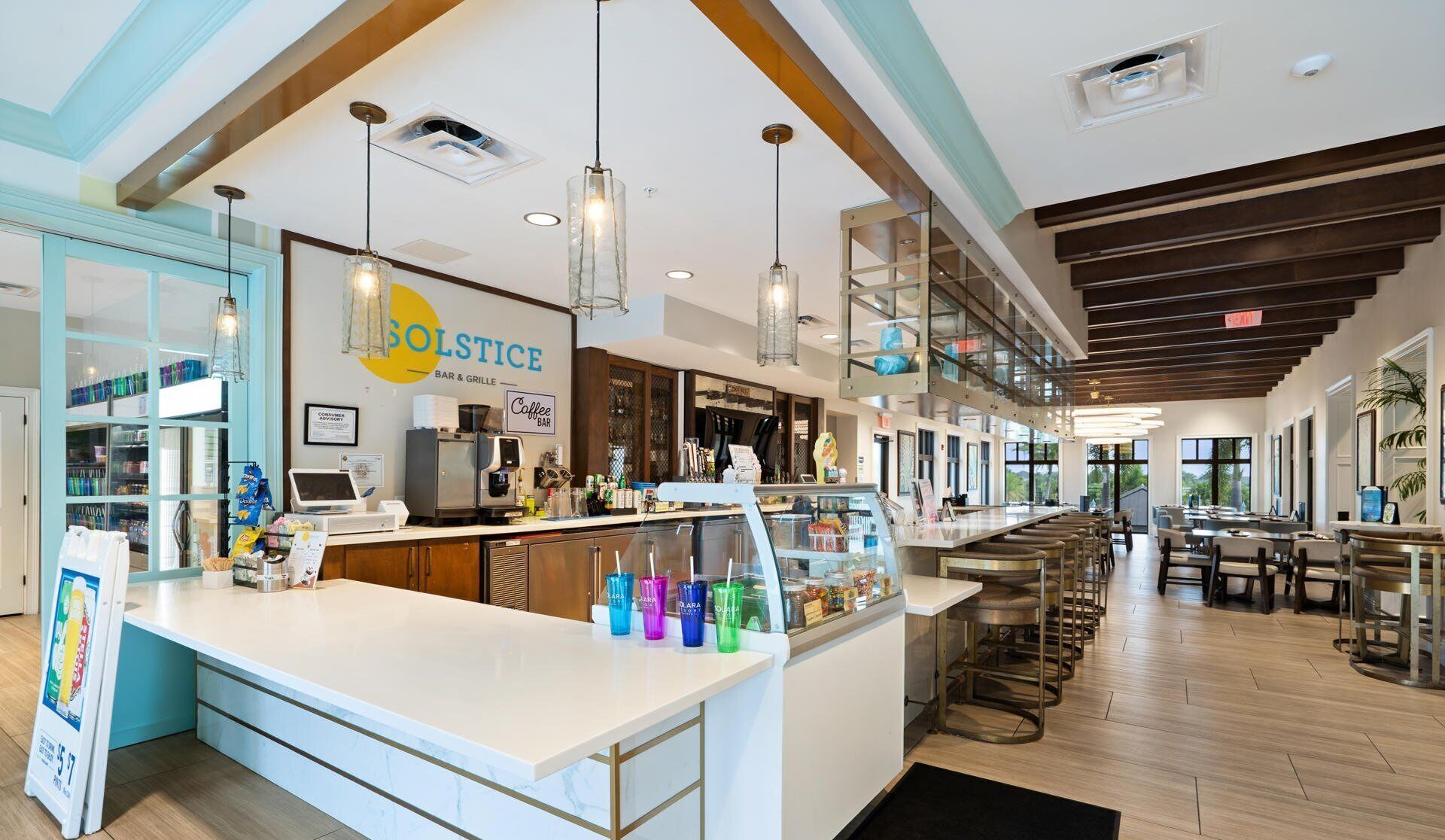 Ein modernes Bar- und Grillrestaurant mit einer zentralen Theke, Barhocker und einer Glasvitrine.