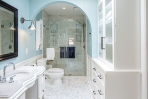 Een bad/douchecombinatie, een haardroger, handdoeken, zeep