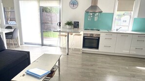 Eine moderne Küche mit Herd, Backofen und einer Uhr an der Wand.