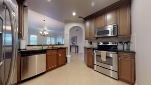 Una cocina moderna con electrodomésticos de acero inoxidable, armarios de madera y una isla central.