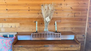 Un escritorio de madera con un jarrón decorativo y velas, sobre un panel de madera.