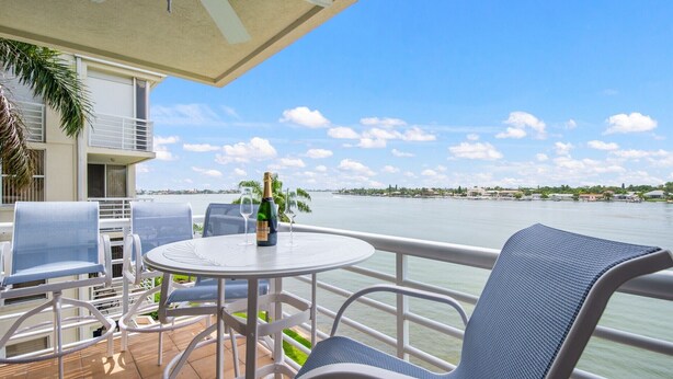 Ein Balkon mit Tisch, Stühlen und einer Champagnerflasche.