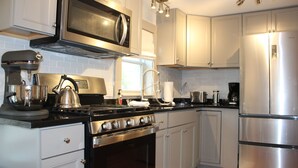 Una cocina moderna con electrodomésticos de acero inoxidable, incluyendo un microondas, estufa y refrigerador.