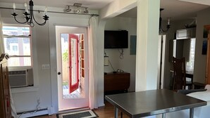 Eine moderne Küche mit einem Edelstahl-Tisch, einem eingebauten Ofen und einem an der Wand befestigten Fernseher.