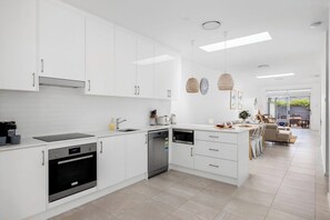 Enjoy cooking in this well-lit kitchen with oven and dishwasher.