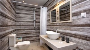 Un bany modern amb un mirall gran, un lavabo i una dutxa.