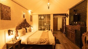 A cozy bedroom with a large bed, a wooden dresser, and a television.