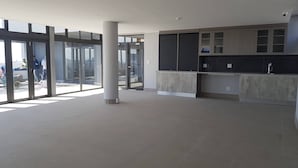 Eine geräumige, moderne Küche mit großen Fenstern, einer zentralen Säule und einer integrierten Spüle.