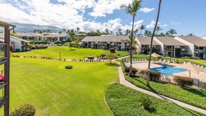 A resort with multiple buildings, a swimming pool, and a well-maintained lawn.