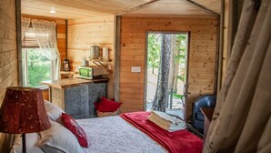 A cozy cabin room with a bed, a desk with a computer, and a window overlooking greenery. - Eagle's Nest For Great Hikes, Local Breweries and Coffee Shops. (Lolo)