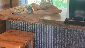 A rustic wooden counter with a tray holding wine glasses and a rustic wooden stool. - Eagle's Nest For Great Hikes, Local Breweries and Coffee Shops. (Lolo)