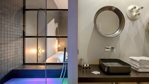 A modern bathroom with a large mirror, a sink, and a heated floor.