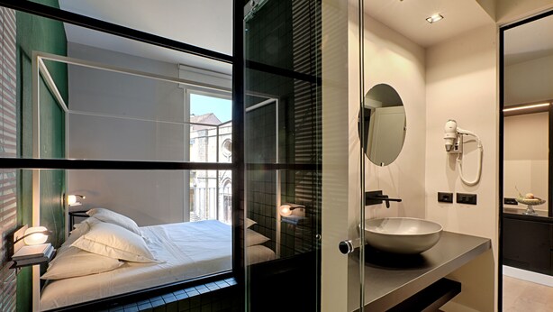 A modern bathroom with a large mirror, a sink, and a shower.
