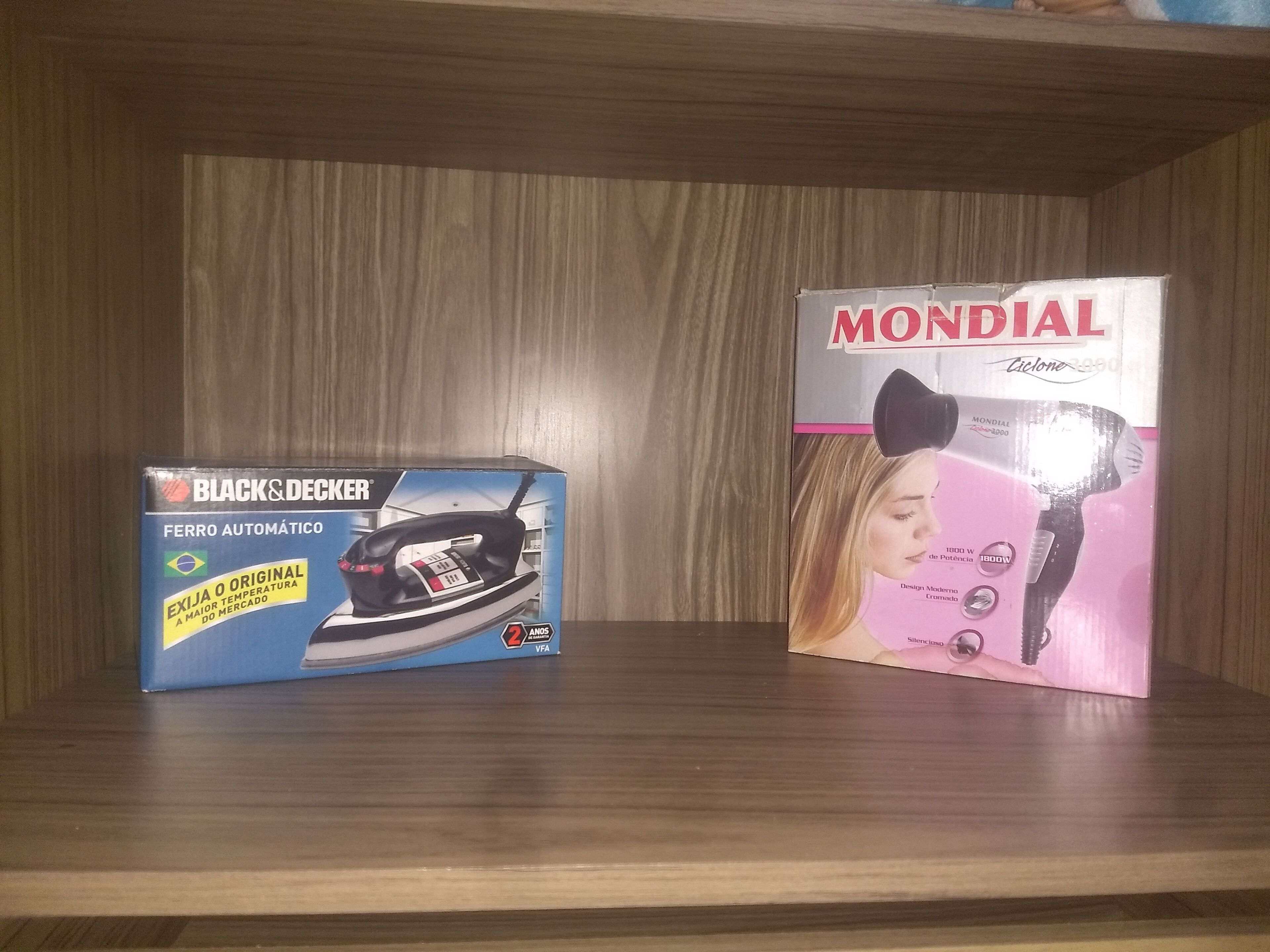 Two boxes of hair styling tools on a wooden shelf.