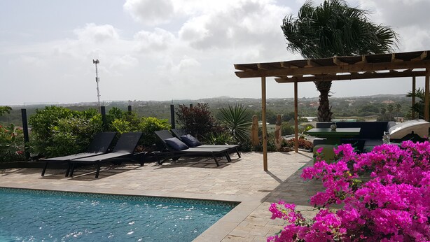 A pool area with lounge chairs, a pergola, and a view of the landscape. - LUXURY HILLTOP VILLA "Het Catshuis" - Private Pool & Panoramic Views (Willemstad)