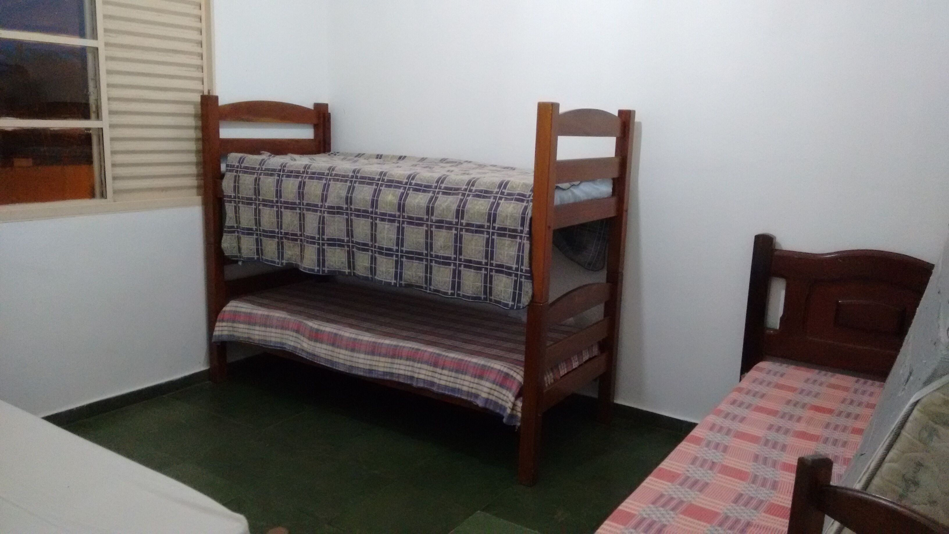 Ein kleines Zimmer mit Etagenbett und Einzelbett.