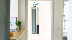Eine moderne Küche mit einer Holzauskładung, einem Laptop und einem Blumentopf.
