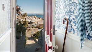 Vista da un balcone su una cittadina costiera, con edifici e cielo sereno.