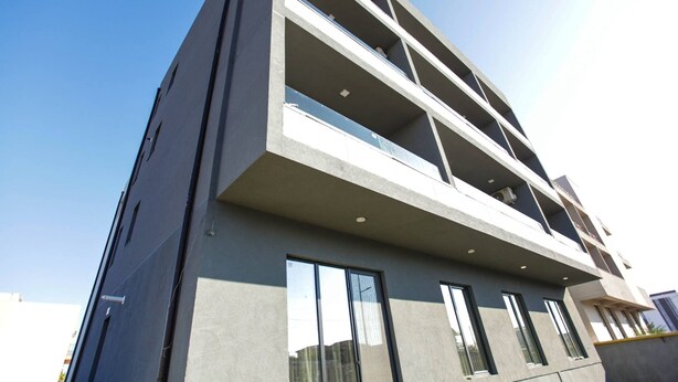 A modern multi-story building with balconies, large windows, and a flat roof. - Beautiful SeaSide Apartments (Mamaia-Sat)