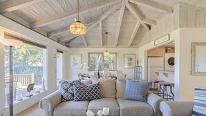 A spacious living room with a high ceiling, a sofa set, and a dining area. - 3786 Adobe by the Sea ~ Golf View, Walk to Beach (Pebble Beach®)