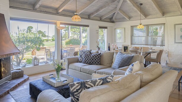A spacious living room with a high ceiling, a fireplace, and a view of the outdoors. - 3786 Adobe by the Sea ~ Golf View, Walk to Beach (Pebble Beach®)