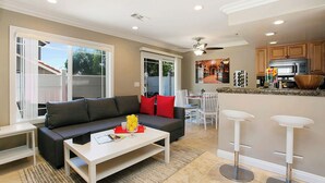 A modern living room with a sofa, coffee table, and a dining area with chairs. - Multi-Level 2BR-Fast WiFI-Free Parking!-CM1 (Costa Mesa)