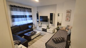 Apartment (Wohnung 1) | Living area | 100-cm flat-screen TV with cable channels, TV, Netflix