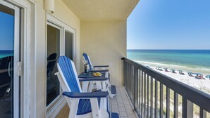 A balcony with a view of the beach, featuring a table with chairs and a small table lamp. - Oceanfront PCB Condo w/ Beach Access & 2 Pools (Panama City Beach)