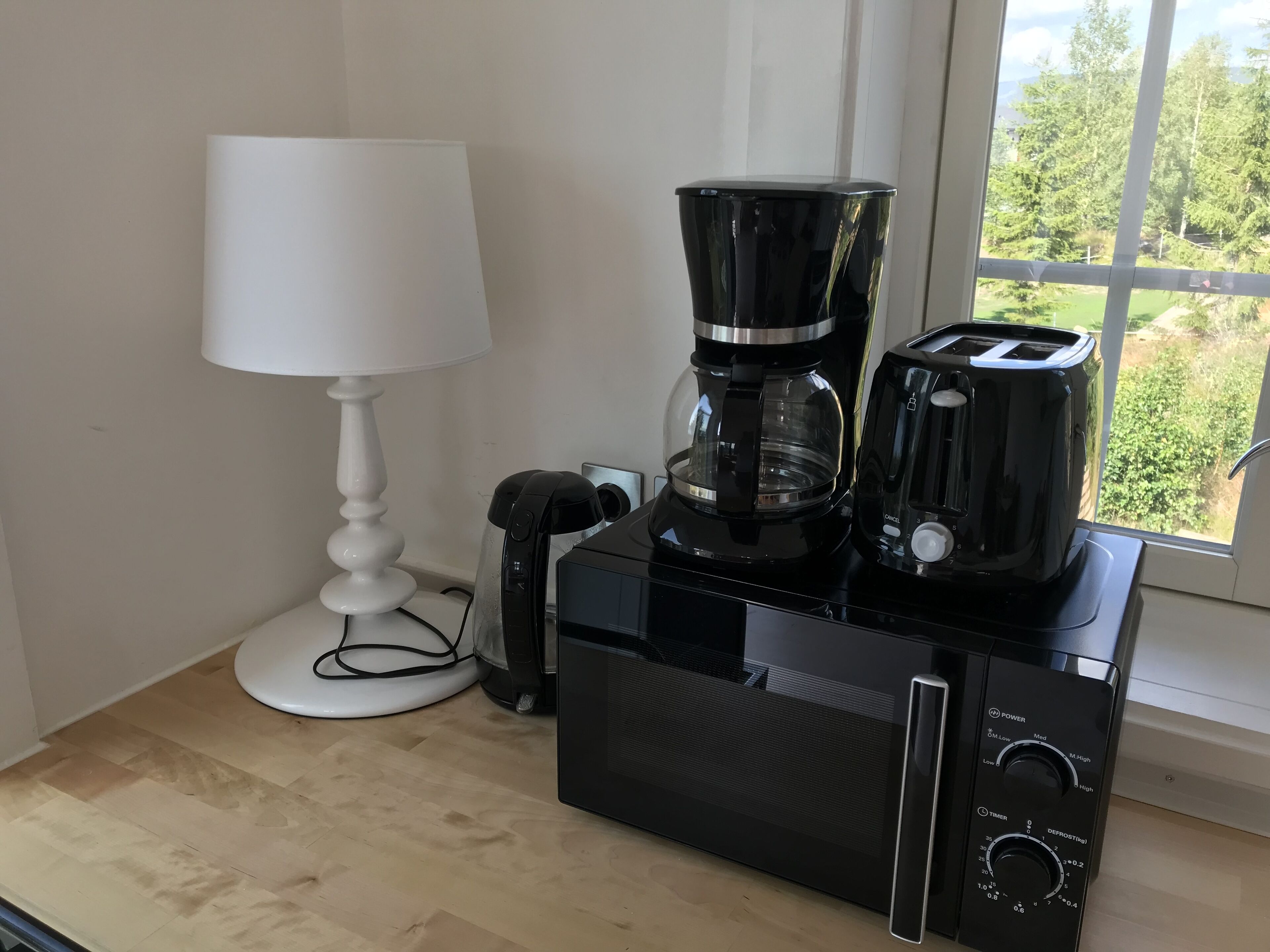 Eine Küche mit Kaffeemaschine, Toaster und einer Lampe auf einer Holzauskład.