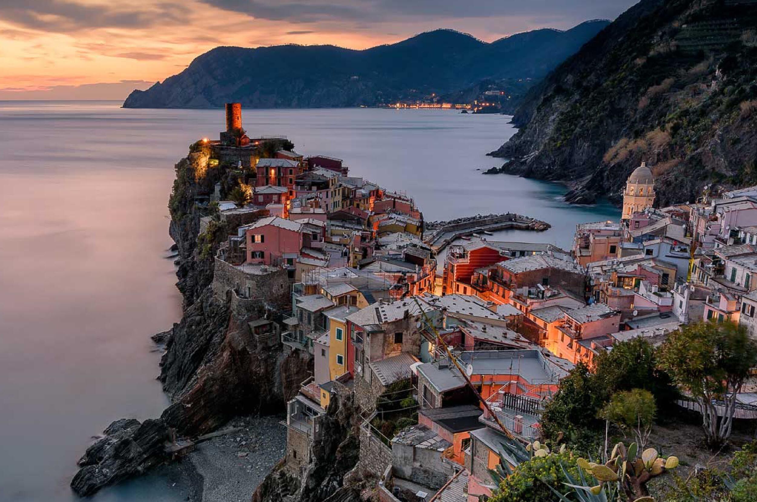 Un pueblo costero con edificios construidos sobre un acantilado con vistas al mar.