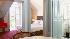 Ett hotellrum med en säng, en stol, ett bord och utsikt över balkongen.