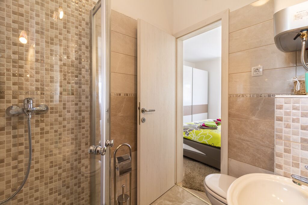 Une salle de bain avec une douche à parois de verre, des toilettes et un lavabo.