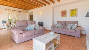 Ein Wohnzimmer mit zwei Sofas, einem Couchtisch und Holzbalkendecke.