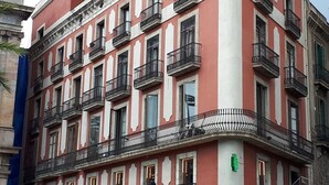 Un edifici de diverses plantes amb balcons i un senyal de prohibició d'aparcament.