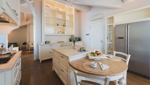 A modern kitchen with white cabinetry, a built-in island, and a stainless steel refrigerator. - VILLA LILLA penthouse on the beach of San Vincenzo Tuscany luxury (San Vincenzo)