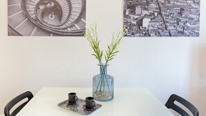 Une table avec deux chaises, un vase avec des plantes et deux tasses sur un plateau.