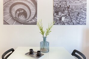 Une table avec deux chaises, un vase avec des plantes et deux tasses sur un plateau.
