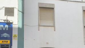 A building with a closed entrance, a visible ATM on the left, and a number '15' above the door. - Renovated apartment right in the city center (Lagos)