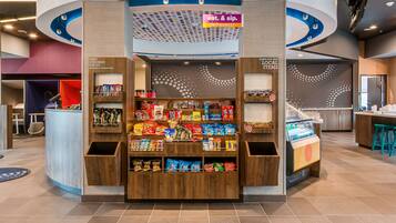 A snack kiosk with a variety of packaged snacks and a beverage machine.