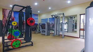 Ein Fitnessstudio mit Gewährterholsystem, Trainingsgeräten und einer Spiegelwand.