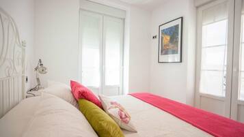 2 dormitorios y tabla de planchar con plancha