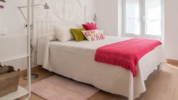 2 dormitorios y tabla de planchar con plancha