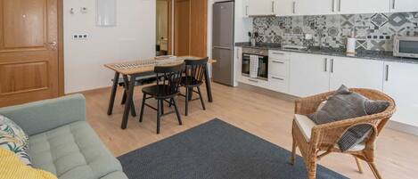 A modern kitchen with white cabinets, a tiled backsplash, and a built-in oven.