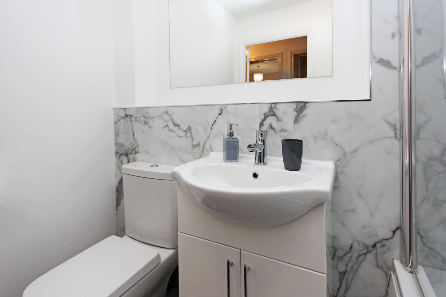 Une salle de bain avec des toilettes, un lavabo et un miroir.