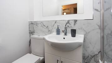Une salle de bain avec des toilettes, un lavabo et un miroir.