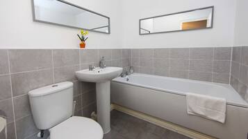 Un baño con inodoro, lavabo y bañera.