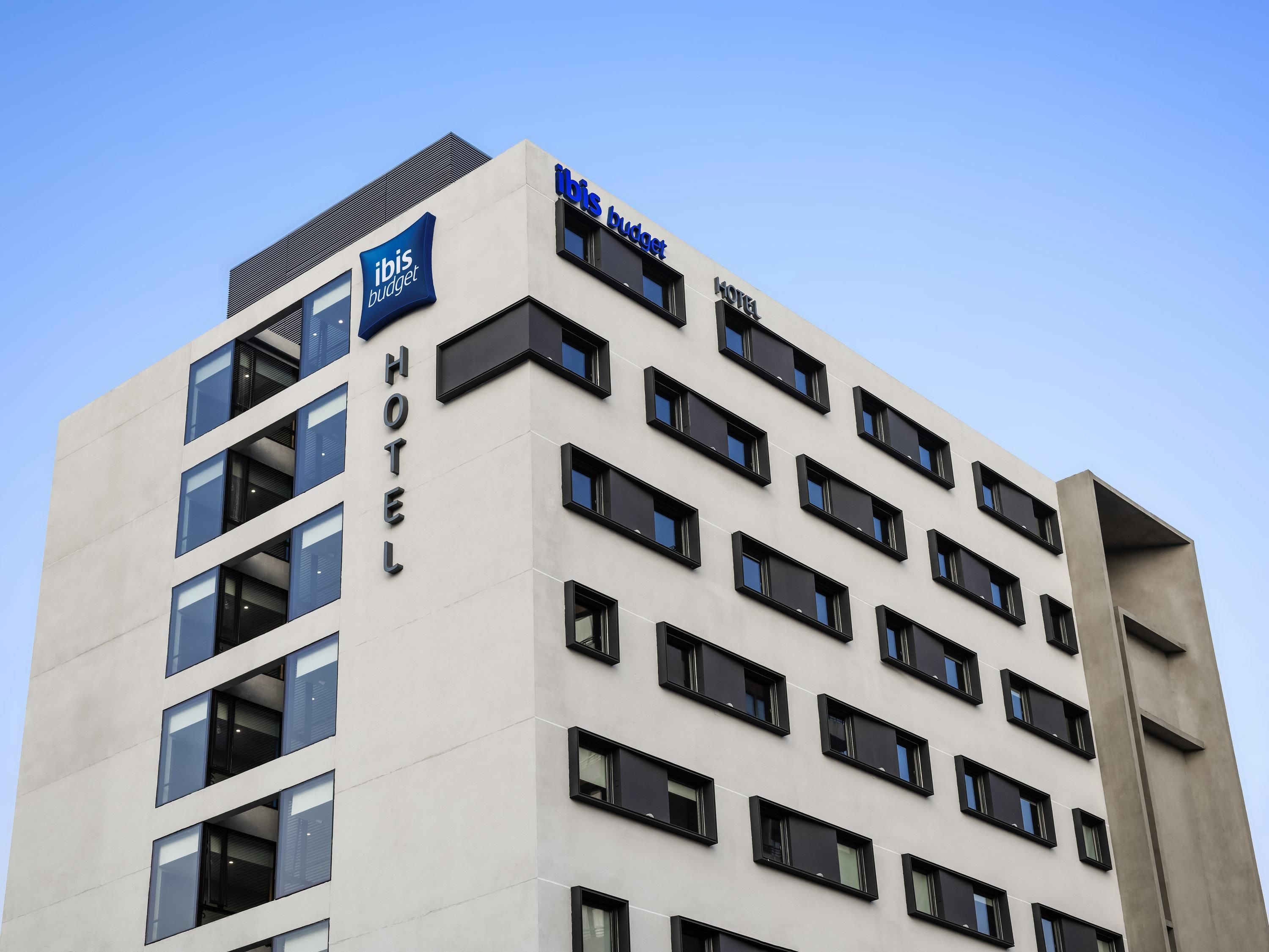 A hotel building with a sign for 'ibis budget' and 'HOTEL' on the facade.